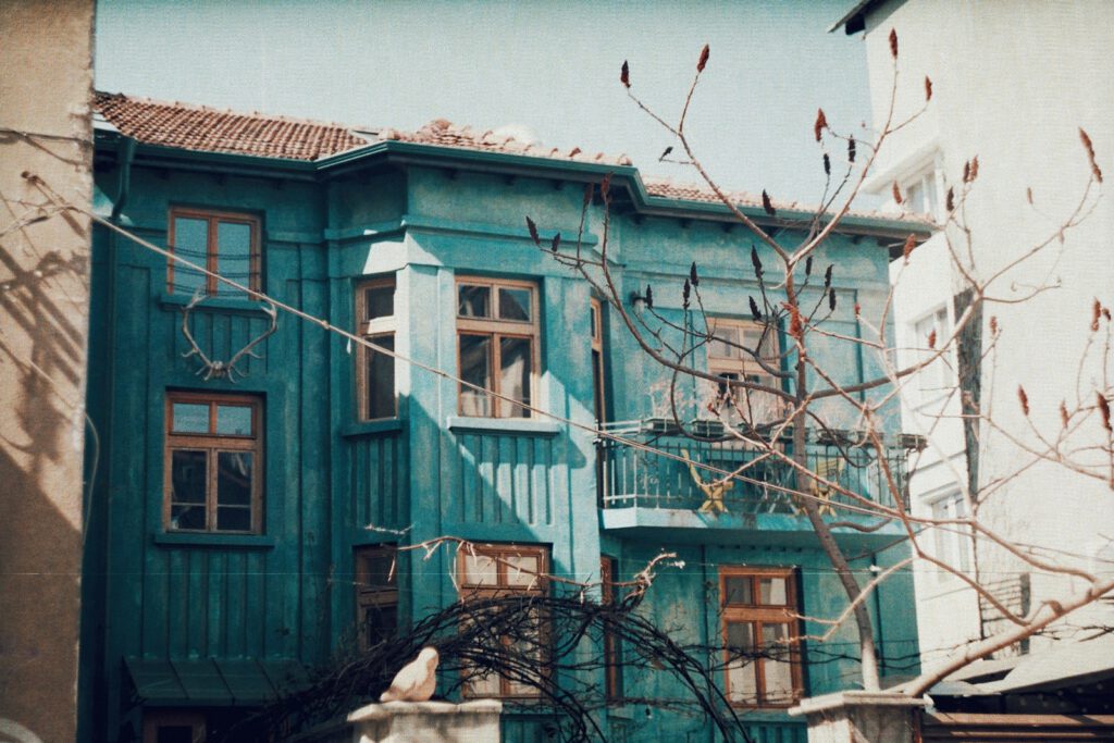 a blue building with a tree in front of it